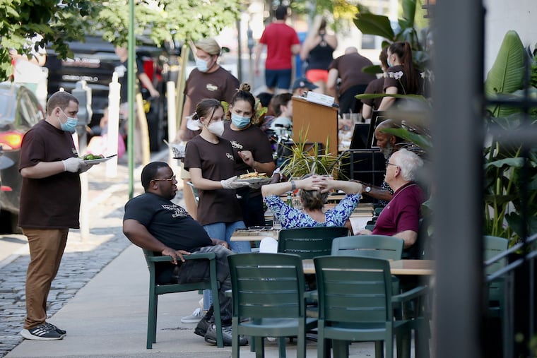 Servers bringing out food to dinnertime customers at Winnie's on Main Street in Manayunk section on June 12.
