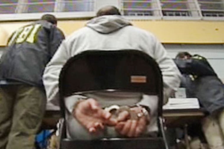 In this frame grab taken from Associated Press Television News video, a suspect sits handcuffed Jan. 20 in the Brooklyn borough of New York. (AP Photo / APTN, Pool)