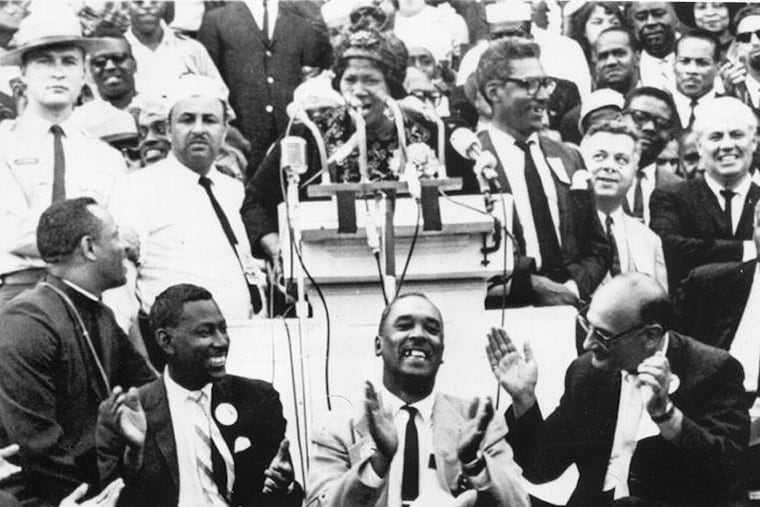 Civil rights leaders smile and clap their hands as Mahalia Jackson sings from the podium of a civil rights rally at the Lincoln Memorial on Aug. 20, 1963.