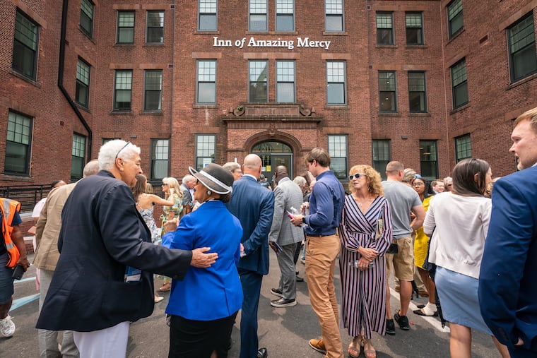 Visitors gather after a news conference in front of Project HOME’s Inn of Amazing Mercy in 2023. The supportive housing project stands to lose federal aid under a Trump administration plan.