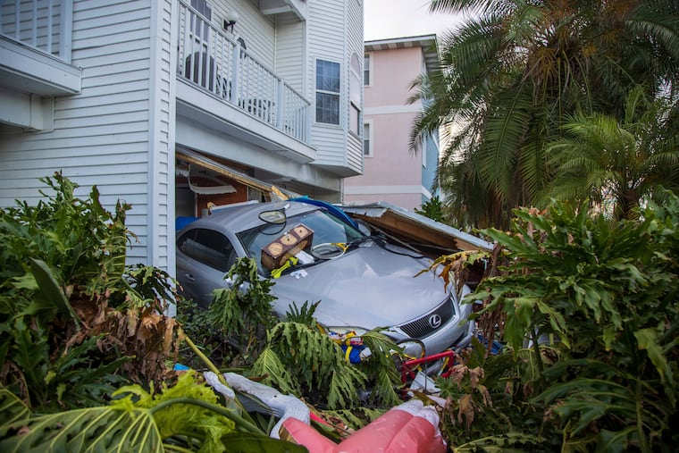 A vehicle sits outside of its garage after storm surge from Hurricane Helene on Saturday in Madeira Beach, Fla.