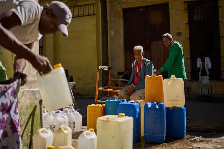 A man fills containers with potable water during a blackout in Havana, in March.