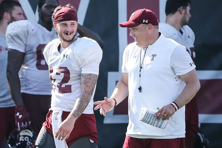 Temple football head coach Geoff Collins chats with quarterback Logan Marchi during practice.