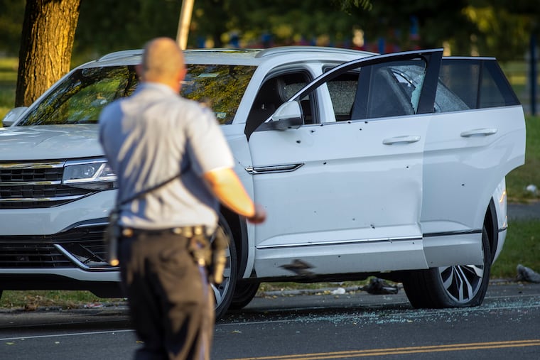 Police investigate a white Volkswagen SUV with bullet holes on North 33rd Street near Diamond Street on Sept. 29, 2021.