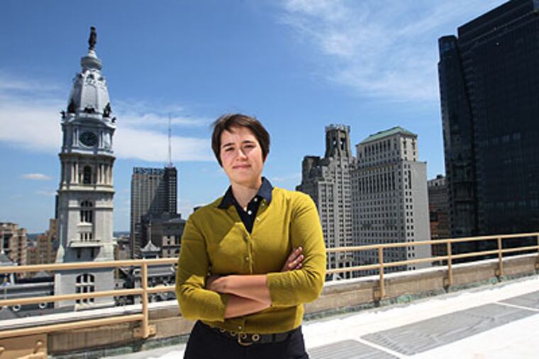 Katherine Gajewski, director of the mayor's office of sustainability, stands on the roof of 1515 Market, the winner of the cool roofs contest. The reflective white color saves the building money in energy costs. (Michael Bryant / Staff Photographer)