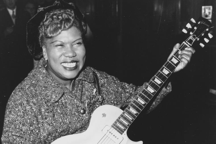 Sister Rosetta Tharpe, guitar-playing American gospel singer, gives an inpromptu performance in a lounge at London Airport, following her arrival from New York on November 21, 1957.