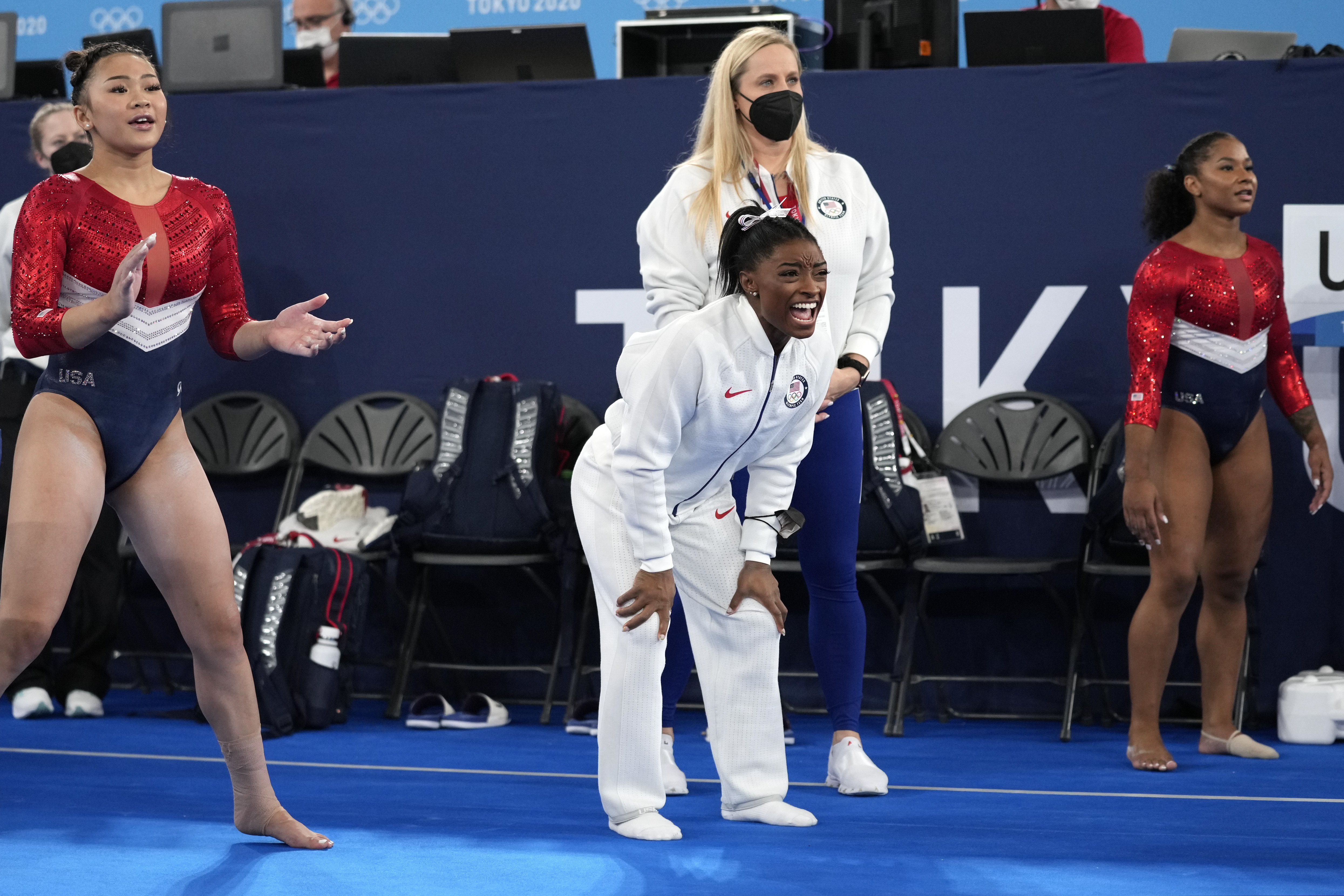 Gymnasts from the United States, Simone Biles, centre, Jordan Chiles , right, and Sunisa Lee cheer the performance of teammate Grace McCallum performs on the floor during the artistic gymnastics women's final at the 2020 Summer Olympics, Tuesday, July 27, 2021, in Tokyo.