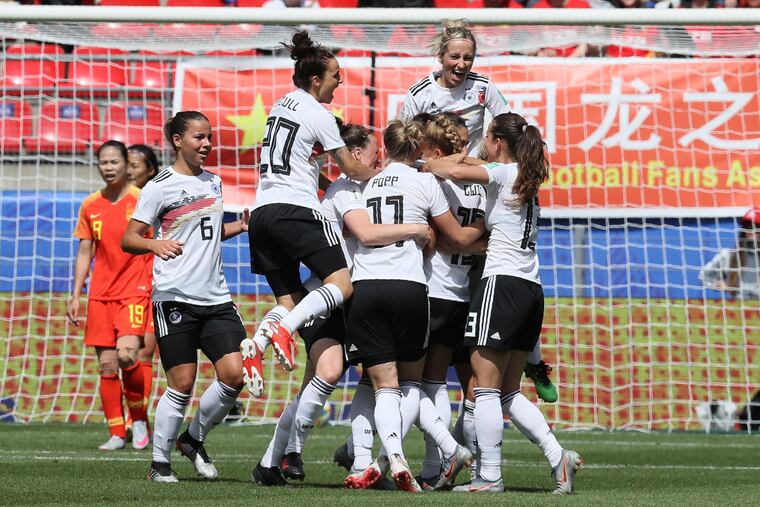 Germany's Giulia Gwinn is cheered by teammates after scoring against China.
