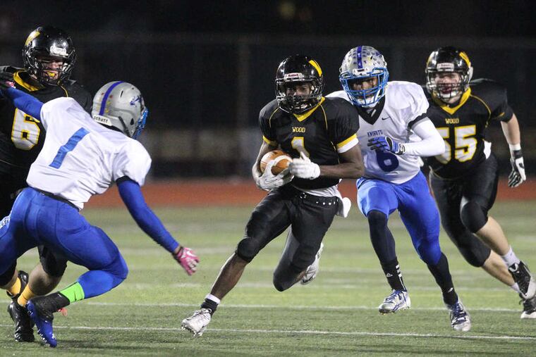 Archbishop Wood's Jarrett McClenton (center) tries to outmaneuver Academy Park defenders Brian Ingram (left) and Jeff DeVaughn (second from right) in a Nov. 29 playoff game. CHARLES FOX / Staff Photographer