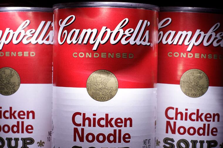 Cans of Campbell's Chicken Noodle Soup are posed in San Diego. Campbell Soup Co. on Tuesday, Nov. 19, 2013 said its quarterly profit fell 30 percent as U.S. sales of soups and V8 beverage declined. A recall of its recently acquired Plum Organics products also hurt results and the company cut its outlook for the year. (AP Photo/Gregory Bull, File)