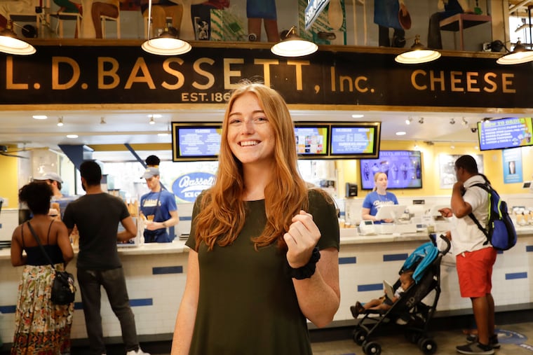Recent Temple graduate Claire Dabney stands near the Bassetts Ice Cream shop at the Reading Terminal Market on Monday, July 15, 2019. The Lancaster native is staying in Philly and Reading Terminal Market is one of her favorite places.