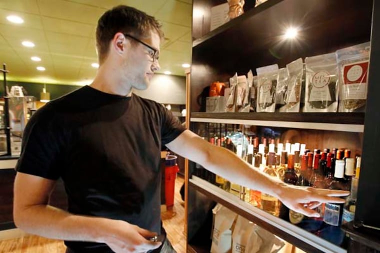 Jersey Java manager Ken Kouba opens the locked case that contains the different Auburn Road Vineyard and Winery wines that are now available at Jersey Java and Tea Co. in Haddonfield on September 18, 2014. ( ELIZABETH ROBERTSON / Staff Photographer )