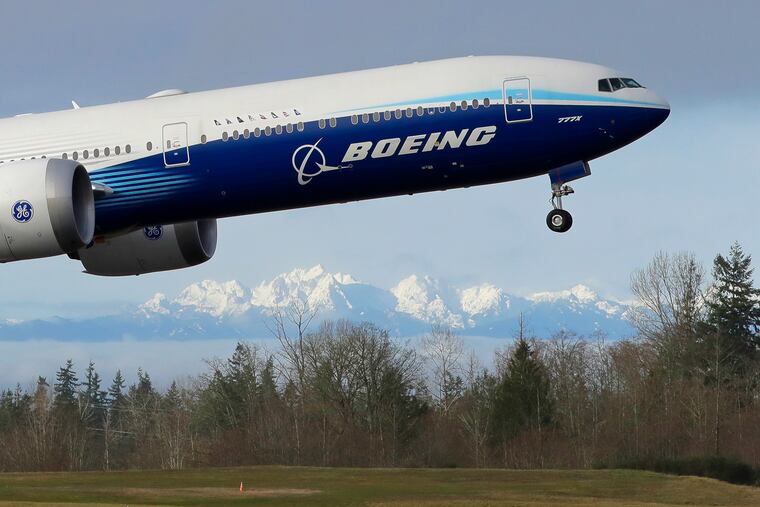 FILE - In this Jan. 25, 2020, file photo a Boeing 777X airplane takes off on its first flight with the Olympic Mountains in the background at Paine Field in Everett, Wash. Boeing Co. reports earnings on Wednesday, Jan. 25, 2023.