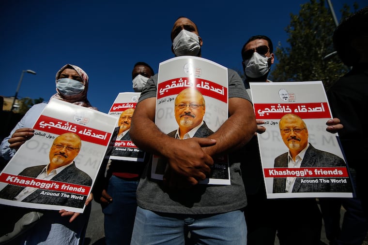 People hold posters of slain Saudi journalist Jamal Khashoggi, near the Saudi Arabia consulate in Istanbul, during an event marking the two-year anniversary of his death, Friday, Oct. 2, 2020. The gathering was held outside the consulate building, starting at 1:14 p.m. marking the time Khashoggi walked into the building where he was found tragically dead.