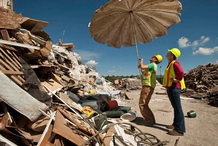 Billy Blaise Dufala opens a patio umbrella he found while walking among the recycling center's "inventory" with RAIR cofounder Fern Gookin.
