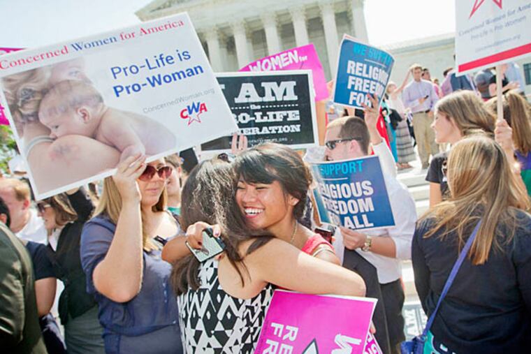 Demonstrators embrace as they react to hearing the Supreme Court's decision on the Hobby Lobby case outside the Supreme Court in Washington, Monday, June 30, 2014. The Supreme Court says corporations can hold religious objections that allow them to opt out of the new health law requirement that they cover contraceptives for women.(AP Photo/Pablo Martinez Monsivais)