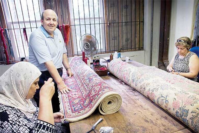 Robert Zakian, stands in his rug-cleaning shop with rug restorers Fatiha Loudini (left) and Maro Kezelyan. (Alejandro A. Alvarez / Staff Photographer)