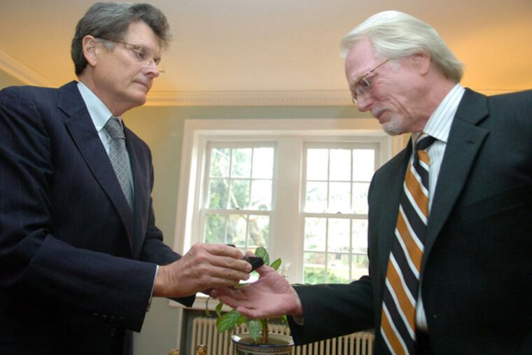 Jess DeVaney (left) hands Joe Winder the dog tag that belonged to his brother David F. Winder. During a June tour in Vietnam, DeVaney's group recovered about 200 dog tags.