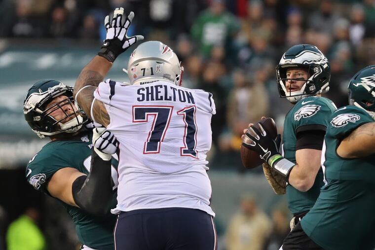 Eagles right tackle lane Johnson, left, protects his quarterback, Caerson Wentz, right, from New England’s defensive lineman Danny Shelton, in the first quarter of Sunday’s game against the Patriots at Lincoln Financial Field on November 17, 2019.
