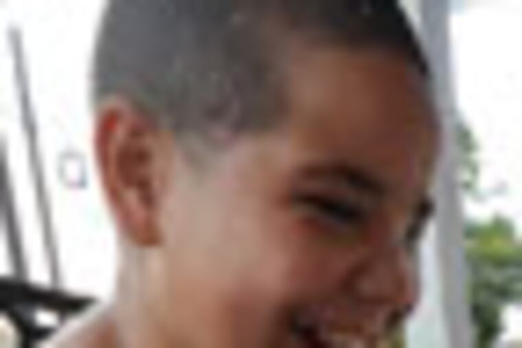 B-JJORGE08P1 In Camden, Jorge Cartagena plays with a keyboard he was given after losing his eyesight to a bullet in June. With him is his cousin Gabriel Del Valle, 8. ( Inquirer / April Saul )