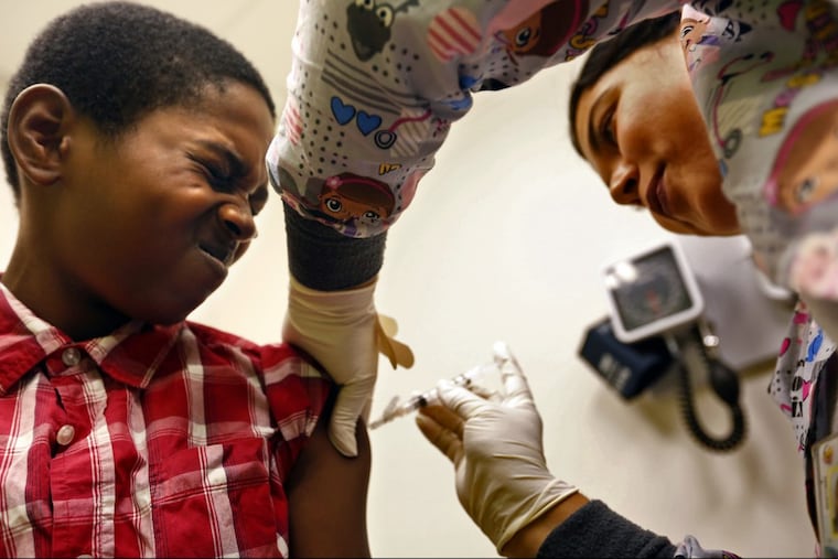 Desmond Sewell, 12, receives a vaccination in Los Angeles.