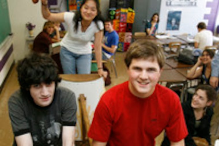 Latin students Jeremy Silver (left) and Erik Schmalbach demonstrate how the chariot they built for a competition is pulled. Diana Wu is in the driver's seat.