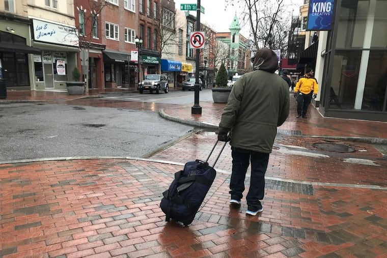 A homeless man who identified himself as Ricky lugs his belongings down downtown Wilmington’s Market Street in March 2020.