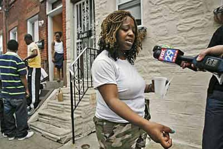 Shanea Williams, said to be divorcing the Philadelphia police officer accused of shooting and killing a South Philadelphia man during a altercation on Sunday, gestures Monday as if she were holding a gun in the way she says her ex-husband shot her brother. (ALEJANDRO A. ALVAREZ / Staff Photographer)