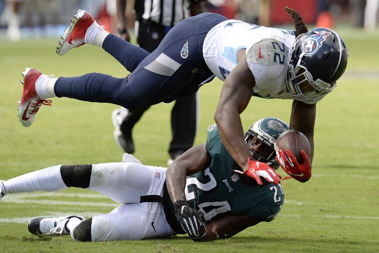 Tennessee Titans running back Derrick Henry (22) falls over Philadelphia Eagles defensive back Corey Graham (24) in the second half of an NFL football game Sunday, Sept. 30, 2018, in Nashville, Tenn.