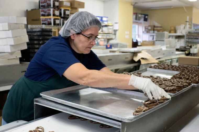 Andrea Burns readies chocolate pretzels for packaging at Giambri's in Clementon. ( ED HILLE /Staff Photographer )