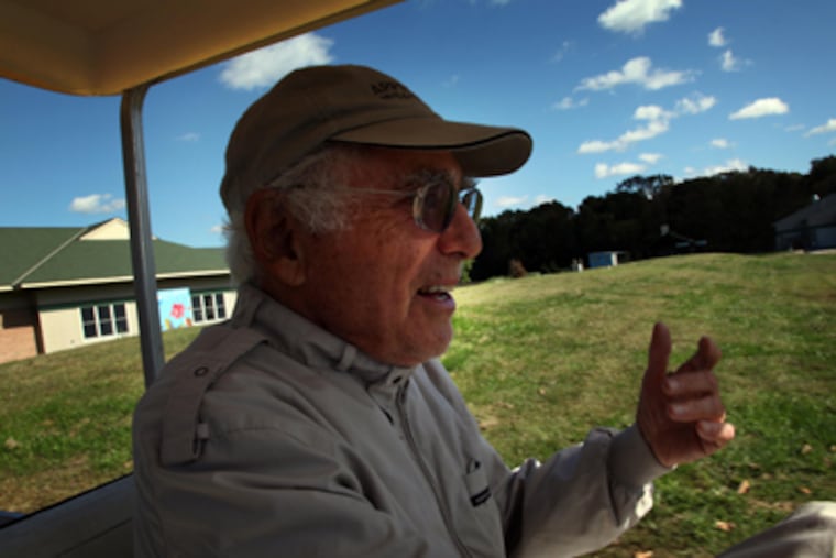 Albert Appel, 88, who started the summer arts camp for children on his farm in 1960, drives a golf cart around the 176-acre property. (Laurence Kesterson / Staff Photographer)