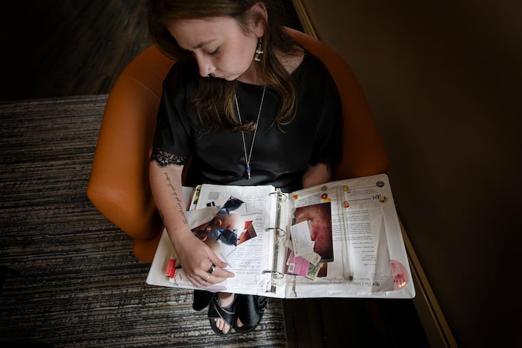 Emma Walz looks through photos and documents her family archived in a binder during her cancer treatment at Children’s Hospital of Philadelphia. Walz, who was treated for a rare childhood cancer as part of a clinical trial, later returned to begin her career there after graduating. Her experience also inspired her father to work in the clinical trial field.