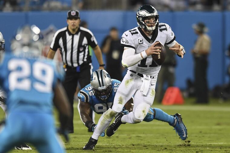 Eagles quarterback Carson Wentz scrambles away from Panthers defensive end Charles Johnson in the Eagles 28-23 win on Thursday.