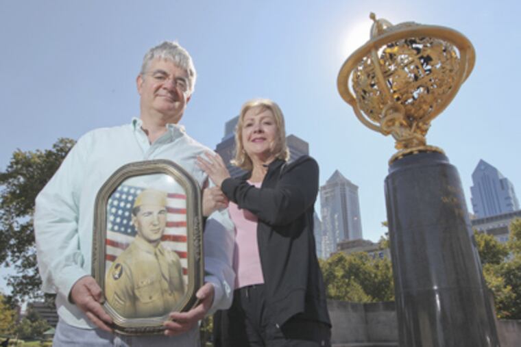 Paul Karosas and Monica Cullen hold a portrait of their uncle Joseph Karaso near the Franklin Institute. (Michael Bryant / Staff Photographer)