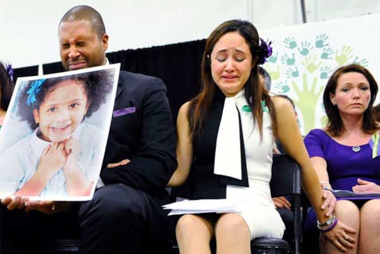 In Newtown, Conn., parents of some of the children killed last month gathered to urge a national dialogue to prevent similar tragedies. Jimmy Greene holds a picture of daughter Ana as he sits with his wife, Nelba Marquez-Greene, and Nicole Hockley (right). (Jessica Hill / AP)