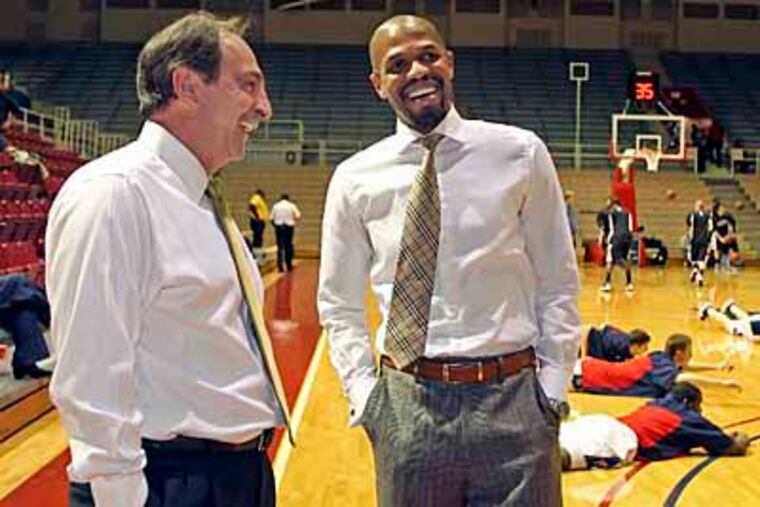 Fran Dunphy, left, chats with one of his former players and Penn's interim coach Jerome Allen. (Steven M. Falk / Staff Photographer)