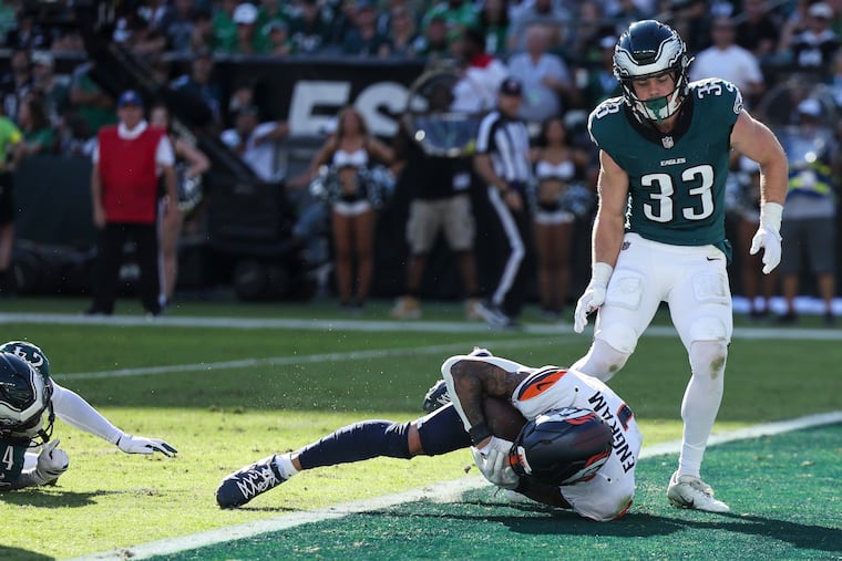 Broncos tight end Evan Engram scores a touchdown as Eagles cornerback Cooper DeJean stands nearby during the fourth quarter.