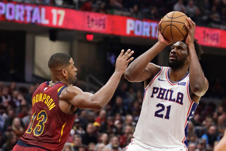 Joel Embiid (right) shoots over Cleveland's Tristan Thompson during the first half.