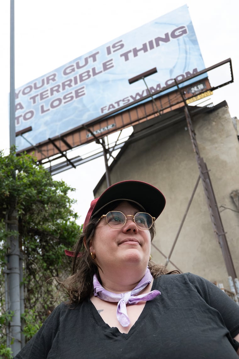 Eisenberg poses with a billboard along Interstate 95 promoting the release of "Fat Swim." 