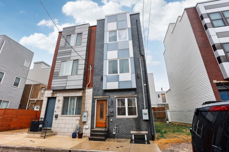 The gray brick rowhouse on the right, finished in 2016, is on the market.
