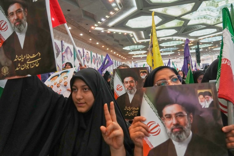Women hold portraits of Iran's Supreme Leader, Ayatollah Mojtaba Khamenei, during a ceremony honoring the armed forces and those killed in the war with Israel and the U.S. at the Imam Khomeini Grand Mosque in Tehran, Iran, Sunday, May 24, 2026.
