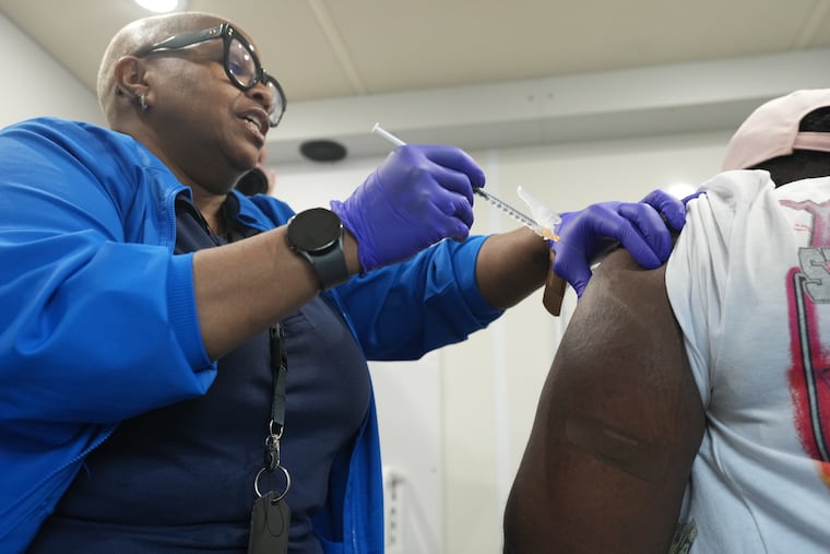 Mia Williams, a registered nurse, vaccinates a client at a mobile clinic in Upper Darby last month.