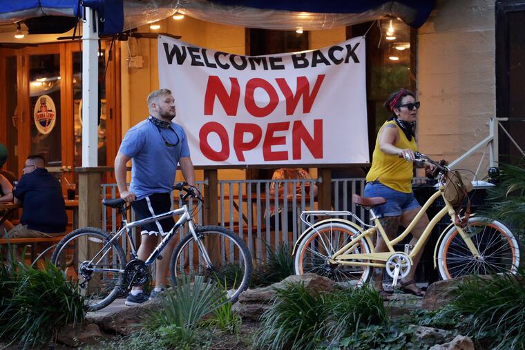Visitors to the River Walk pass a restaurant that has reopened in San Antonio.