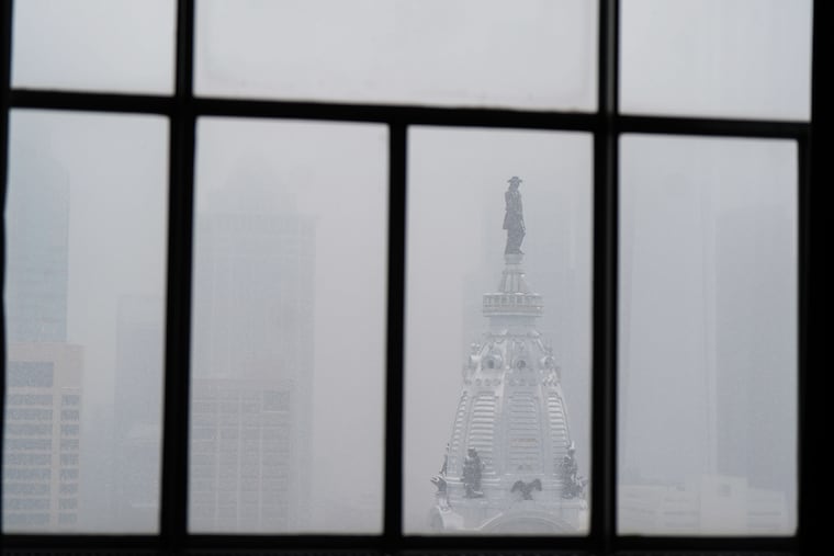 A view through the window of the Loews Hotel of snow falling on City Hall, in Philadelphia on Jan. 19.