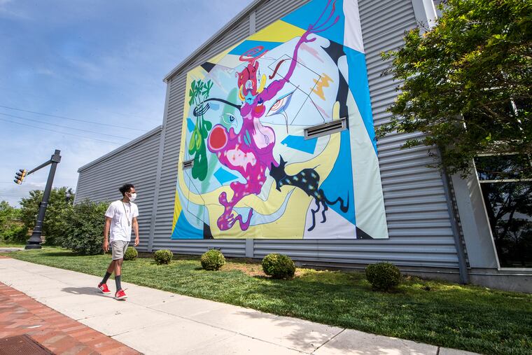 Chris Stevens, security coordinator for The Delaware Contemporary, walks by a work from abstract artist Theresa Chromati that is part of the museum's "Art Escape Drive-Thru."