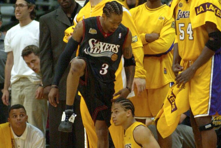 Allen Iverson steps over a Tyronn Lue, who fell attempting to guard Iverson, after draining a three point shot from the corner to put the Sixers up 103-99 with 39.2 seconds left. Iverson hit two three pointers in the closing minutes of overtime and scored 48 points in leading the Sixers to a 107-101 upset victory. (Photo by Jerry Lodriguss)