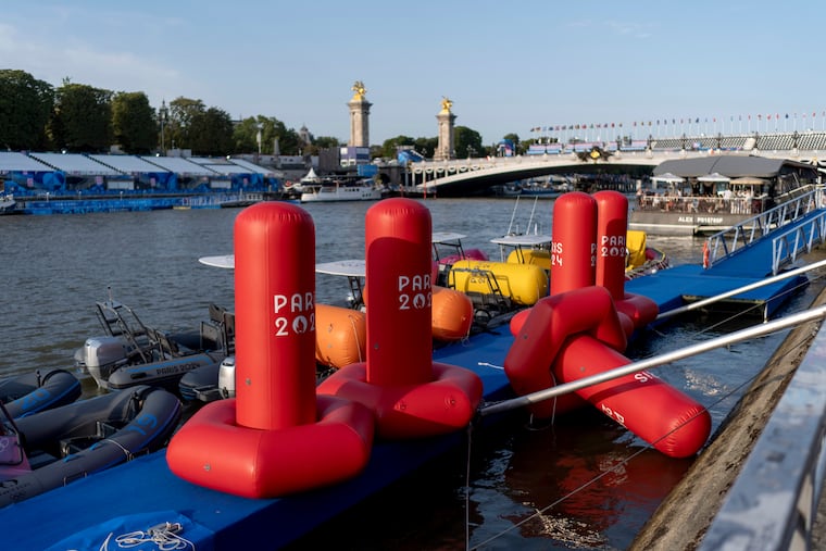 Buoys sit along the Seine River as the triathlon event venue on the Pont Alexandre III bridge stands in the background at the 2024 Summer Olympics on Monday. The Seine's water quality remains a major area of concern for officials, and triathlon organizers postponed the event Tuesday morning.