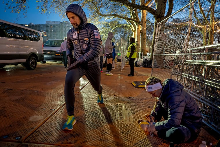 Matt Cavanaugh (left) and Hilary Baude (right) warm up before the 30th annual Philadelphia Marathon on Sunday. They are kidney donors who are running 12 marathons in 12 months around the country to promote the idea that kidney donation does not prohibit an active lifestyle.