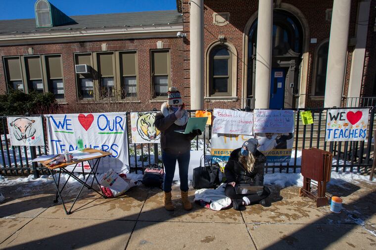 Maureen Sablich, "autistic support" and Sara Musial, life skills teacher (right) working with students virtually outside the Bache-Martin Elementary School at 22nd and Brown St. on Monday, February 8, 2021. Philadelphia school district teachers are protesting the opening of schools without a "safe" plan by school district to keep them and students safe during COVID-19 pandemic.