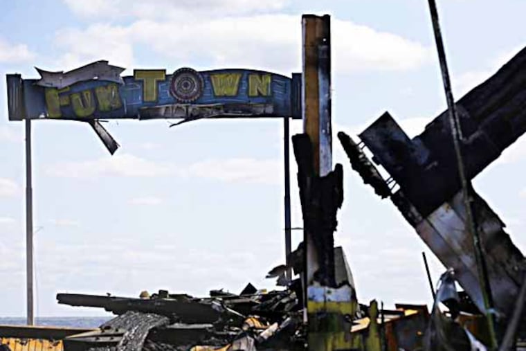 The sign for Funtown Pier stands above charred rubble in Seaside Park, N.J., Tuesday, Sept. 17, 2013, after a fire last Thursday that started near a frozen custard stand in Seaside Park, quickly spread north into neighboring Seaside Heights. More than 50 businesses in the two towns were destroyed. The massive boardwalk fire in New Jersey began accidentally, the result of an electrical problem, an official briefed on the investigation said Tuesday. (AP Photo/Mel Evans)